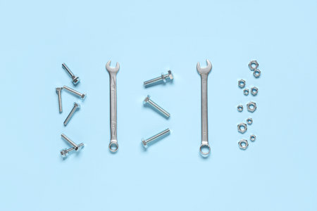 Tap bolts, chrome nuts and wrenches on blue background