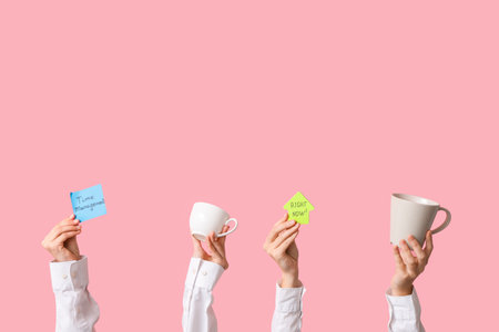 Female hands with coffee cups and sticky notes on pink background. Time management conceptの写真素材