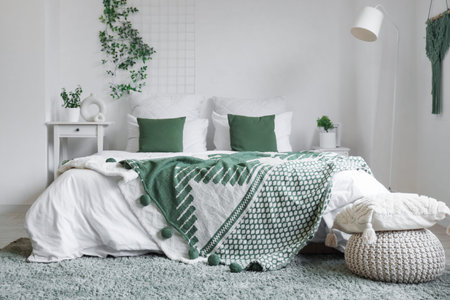 Interior of bedroom with table, pouf and green plantsの写真素材