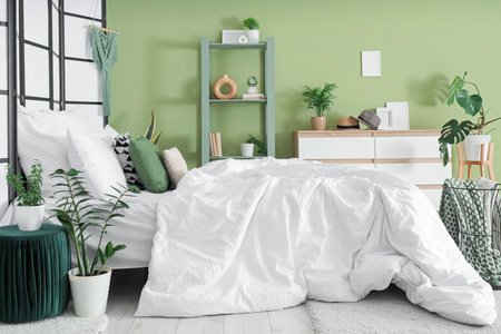 Interior of bedroom with shelf unit, drawers and green plantsの写真素材