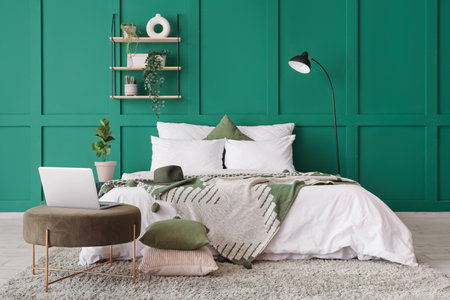 Interior of bedroom with lamp, shelf and laptop on poufの写真素材