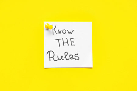 Pinned paper with text KNOW THE RULES on yellow backgroundの写真素材