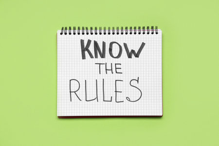 Notebook with text KNOW THE RULES on green backgroundの写真素材