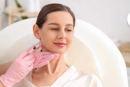 Young girl receiving filler injection in beauty salon