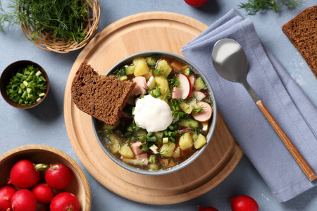 Composition with bowl of tasty okroshka, ingredients, bread and spoon on gray backgroundの写真素材