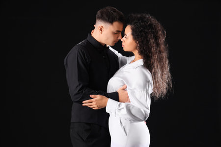 Young couple hugging on black background. Yin Yang concept