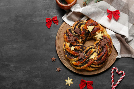 Composition with tasty Christmas pastry wreath, napkin and decorations on dark background