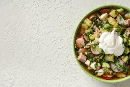 Bowl of tasty okroshka with sour cream on light backgroundの写真素材
