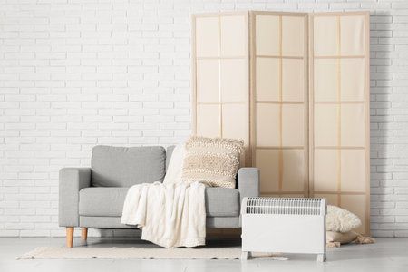 Interior of stylish living room with modern convector heater and gray sofaの写真素材