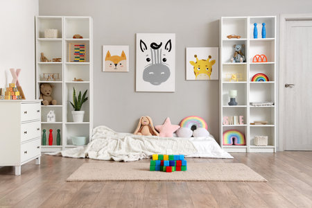 Interior of children's room with bed, shelf units and toysの写真素材