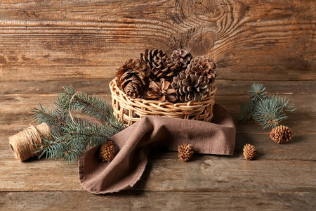 Wicker bowl with pine cones and fir branches on wooden backgroundの写真素材