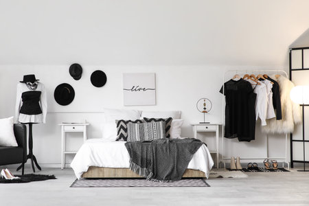 Rack with clothes and mannequin in interior of bedroomの写真素材