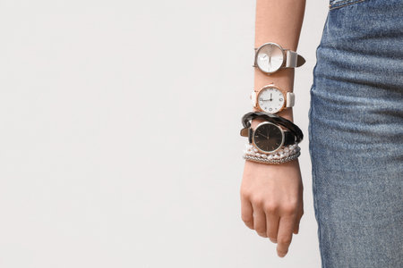 Woman with wristwatches and bracelets on white background, closeupの写真素材