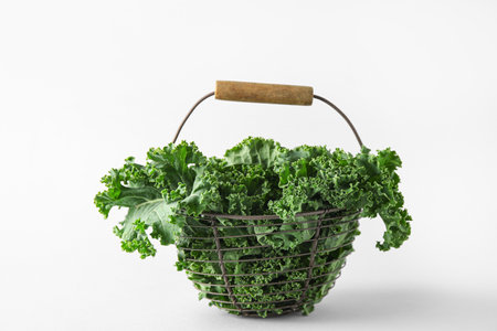 Basket with fresh leaves of kale cabbage on gray backgroundの写真素材