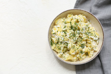 Bowl of tasty potato salad with dill on white backgroundの写真素材