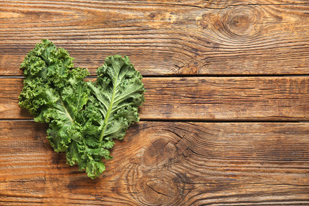 Fresh leaves of kale cabbage on wooden backgroundの写真素材