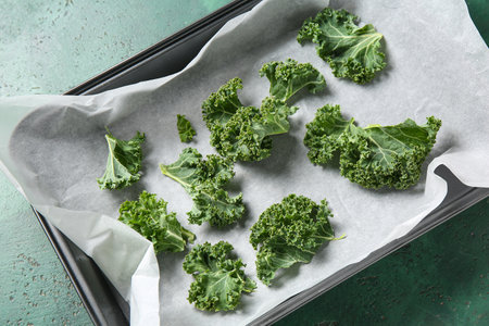 Baking dish with fresh leaves of kale cabbage on green backgroundの写真素材