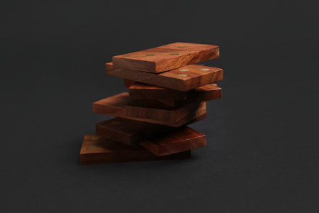 Stack of wooden dominos blocks on black background
