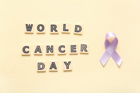 Lilac awareness ribbon with text WORLD CANCER DAY on beige backgroundの写真素材