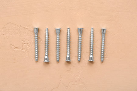 Row of screws on beige backgroundの写真素材