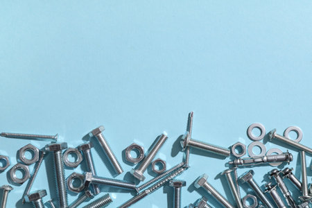 Different tap bolts and chrome nuts on blue backgroundの写真素材