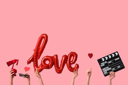 Female hands with movie clapper, paper hearts, 3D glasses, heeled shoe and air balloon in the shape of the word LOVE on pink background. Valentine's Day celebrationの写真素材