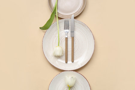 Stylish table setting with beautiful tulip flowers on beige backgroundの写真素材