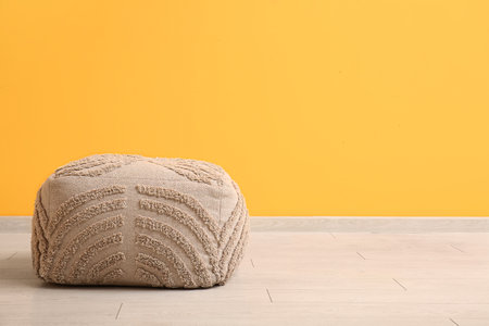 Gray pouf near yellow wall in roomの写真素材