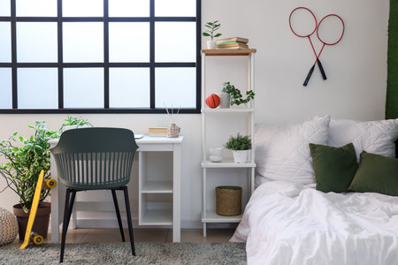 Interior of student's room with bed, shelf unit and study tableの写真素材