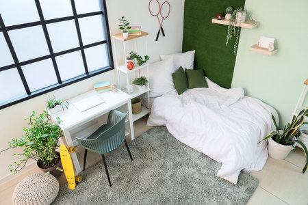 Interior of student's room with bed, shelf unit and study table