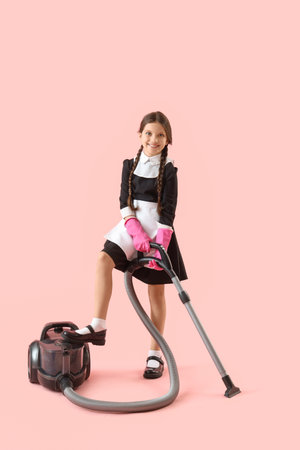 Cute chambermaid with vacuum cleaner on pink backgroundの写真素材