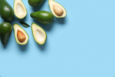 Fresh ripe avocados on blue background