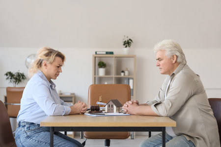 Upset mature couple sitting at divorce lawyer's officeの写真素材