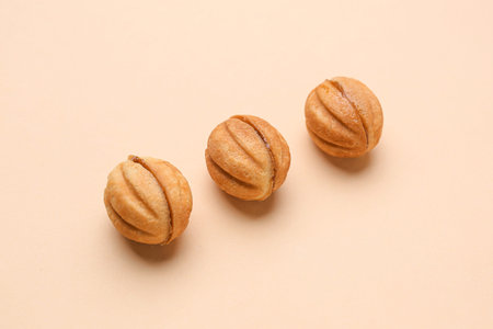 Sweet walnut shaped cookies with boiled condensed milk on beige background
