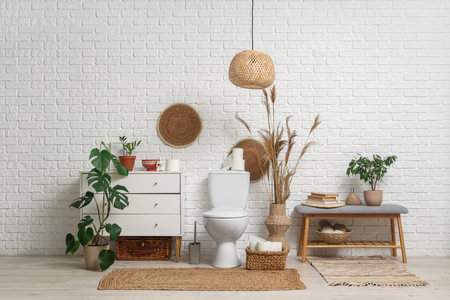 Interior of restroom with toilet bowl, chest of drawers and bench