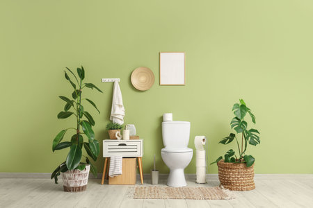 Interior of restroom with toilet bowl, bedside table and houseplants