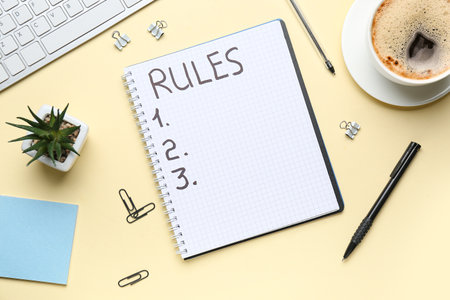 Notebook with blank list of rules, paper clips and computer keyboard on beige backgroundの写真素材