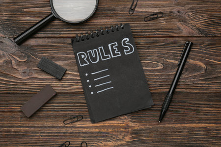 Notebook with blank list of rules and stationery on wooden backgroundの写真素材
