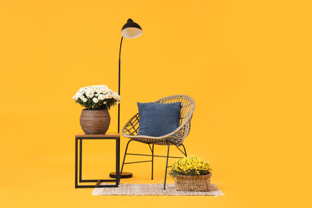 Armchair, floor lamp and chrysanthemum flowers on yellow backgroundの写真素材