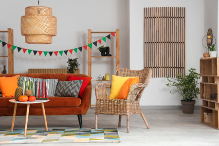 Interior of living room decorated for Kwanzaa celebration with red sofa, armchair and tableの写真素材