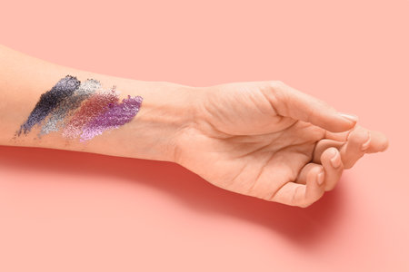 Female hand glitter samples on color backgroundの写真素材