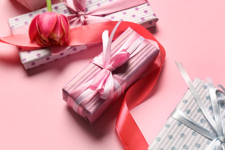 Gift boxes with tulip on pink background. Happy Women's Dayの写真素材