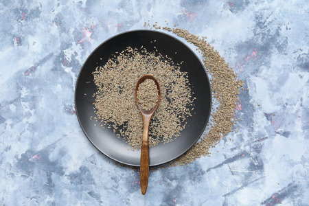Plate and spoon with aromatic anise seeds on color grunge backgroundの写真素材