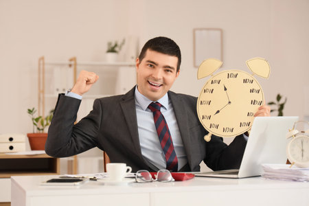 Happy businessman with paper alarm clock in office. Time management concept