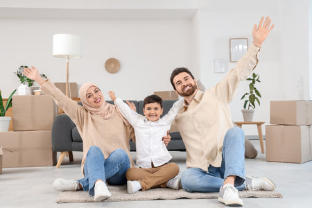 Happy Muslim family sitting in room on moving dayの写真素材