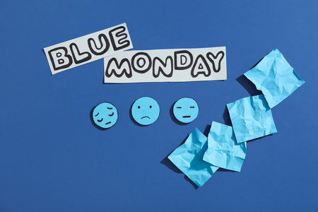 Paper sheets with drawn sad faces and text BLUE MONDAYの写真素材