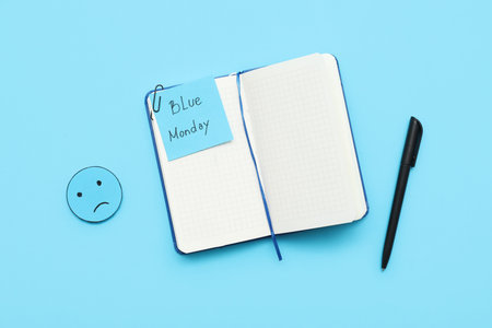 Notebook with pen, drawn sad face and text BLUE MONDAYの写真素材