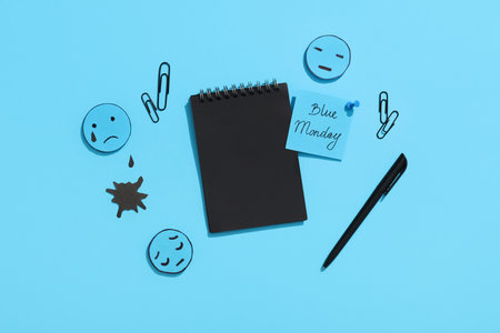 Notebook with office stationery, drawn sad faces and text BLUE MONDAYの写真素材