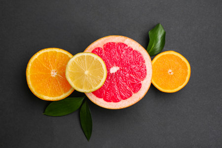 Cut ripe grapefruit with fresh orange and lemon on black backgroundの写真素材