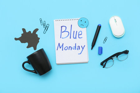 Notebook with written text BLUE MONDAY, cup, eyeglasses and office stationeryの写真素材